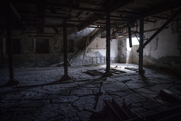 Abandoned industrial dark room with cracked floor