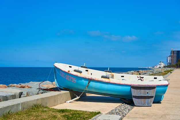 An abandoned old boat on the embankment by the sea in the city of Batumi