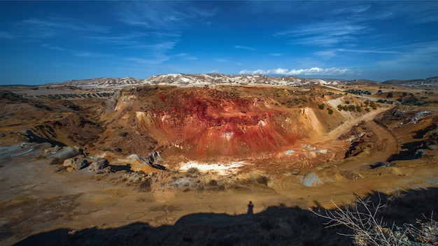 Abandoned open pit of Troulloi copper mine with red cap rich with iron oxides and quartz in Cyprus