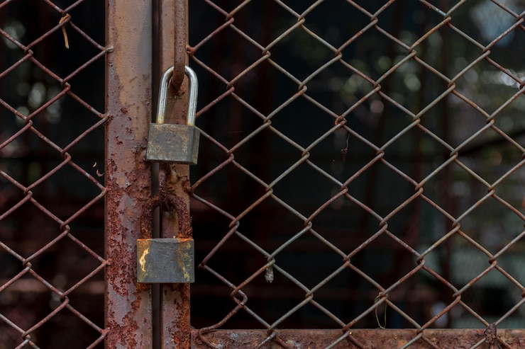 Photo abandoned padlocks locked on rusty wire mesh steel door background