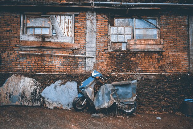 Photo abandoned scooter and building in city