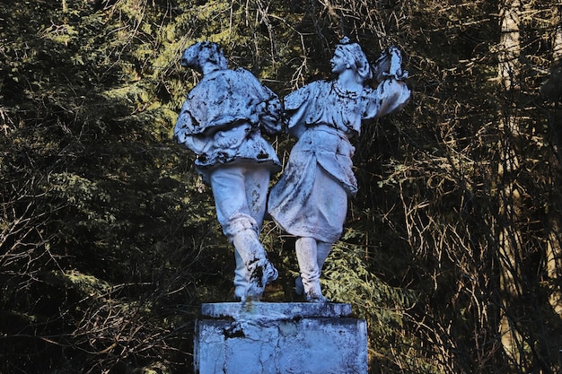 Statua abbandonata di un popolo che balla nella foresta