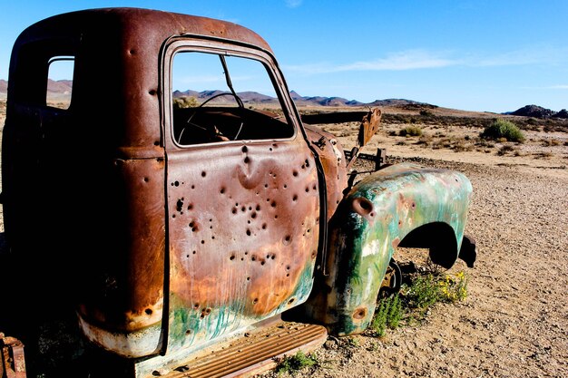 Abandoned truck on field against sky