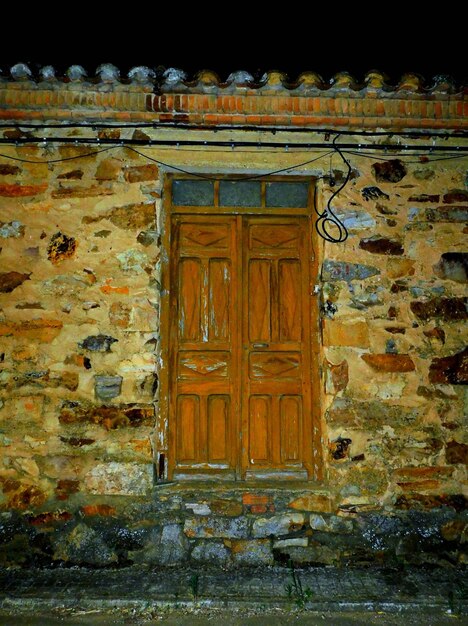 Abandoned village Building with Illuminated Doorway in the Dark