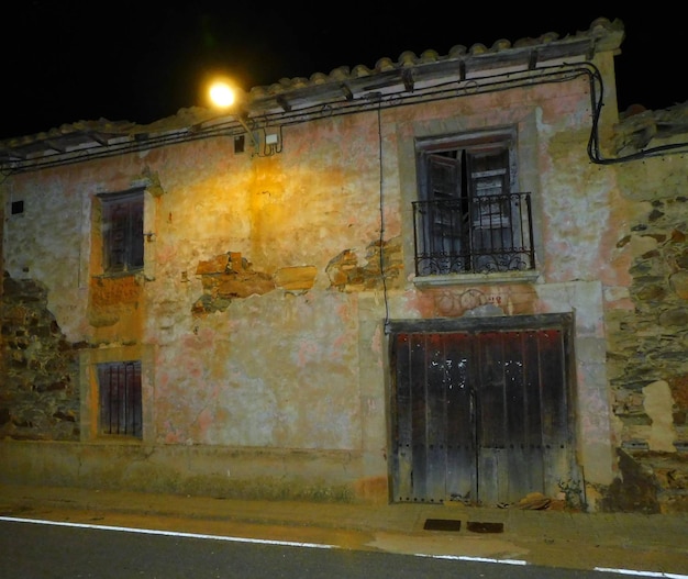 Abandoned village Building with Illuminated Doorway in the Dark