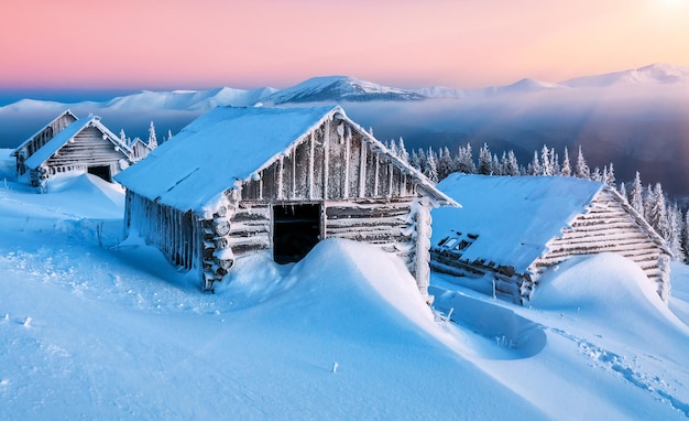 Abandoned wooden cabins in winter Carpathian  mountains at sunrise