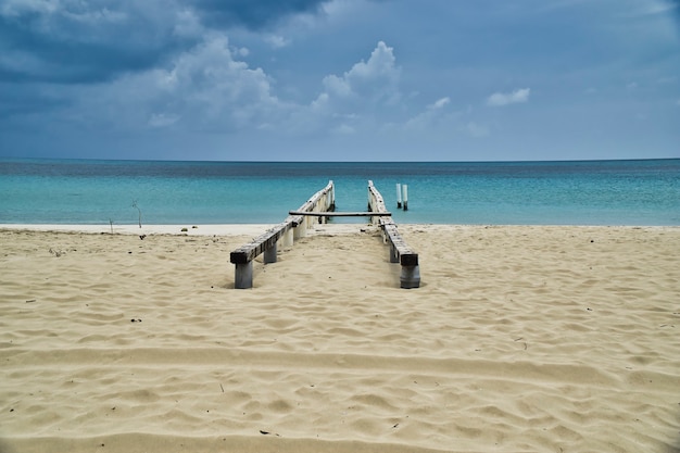 Abandoned wooden dock in Corn island, amazing view of white sand and turquoise water from caribbean sea.