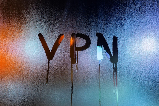 An abbreviation VPN virtual private network drawed by finger on night wet glass