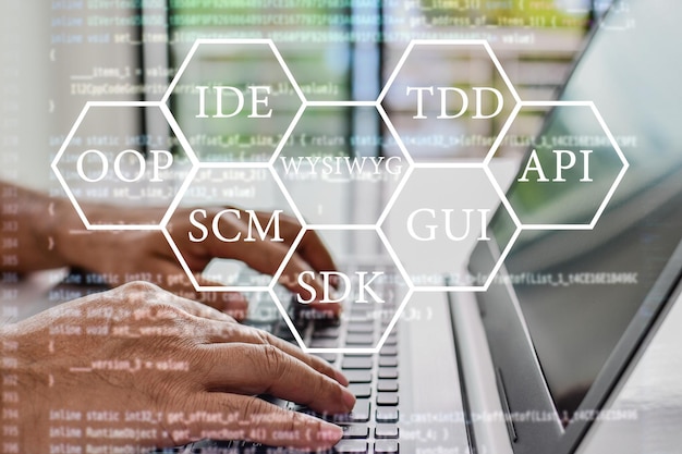 Abbreviazioni che ogni programmatore dovrebbe conoscere come oop scm vcs wysiwyg gui api ide tdd sdk i programmatori si siedono e scrivono programmi con i loro computer portatili close up sfondo sfocato