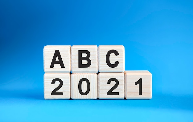 青い背景の上の木製の立方体のABC 2021年