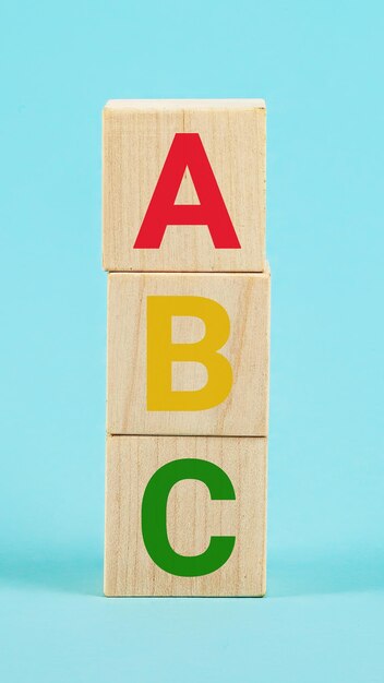 写真 木のブロックにabc 青い背景に柱状の木の立方体ブロックにアルファベット