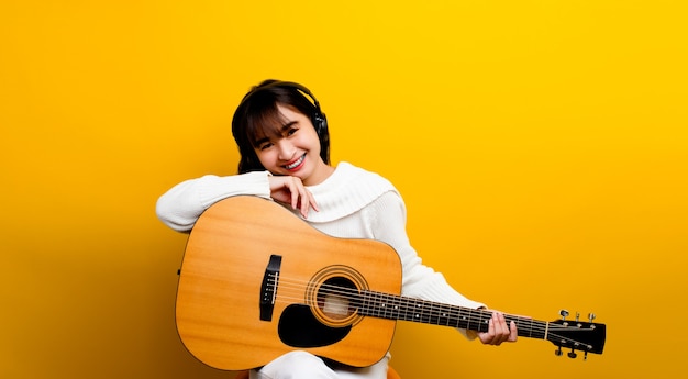 Ability to play guitar asian girl A beautiful woman playing classical guitar smiling and laughing out loud. and enjoyed playing his music.