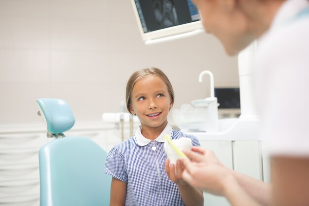 About dental health. Child dentist telling girl about dental health and dental care