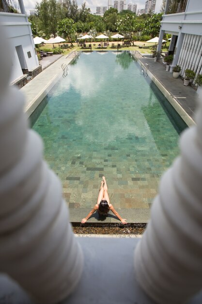 Фото Выше зрения молодой женщины, наслаждаясь бассейн отеля