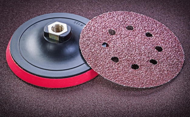 Abrasive discs holder on sandpaper sheet top view.