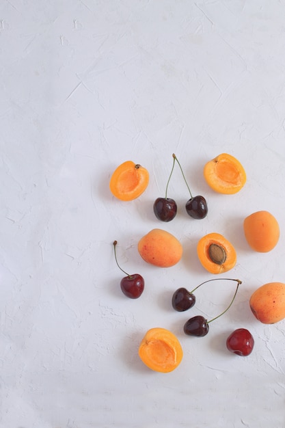 Abrikozen en kersen op wit worden geïsoleerd Zomerfruit en bessen Oogsten