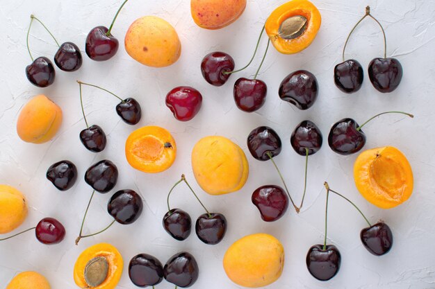 Abrikozen en kersen op wit worden geïsoleerd Zomerfruit en bessen Oogsten