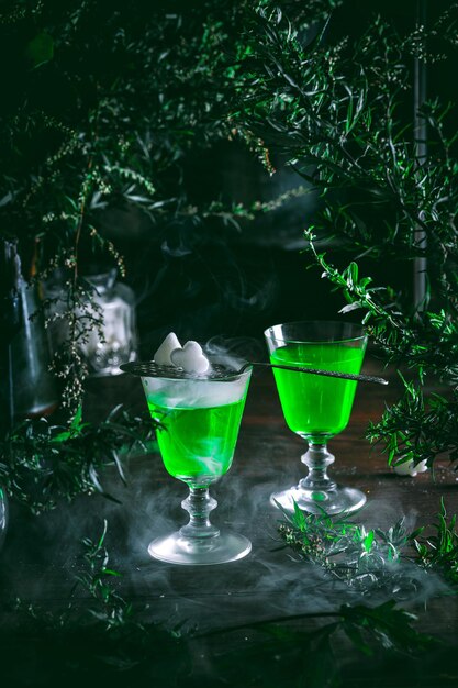 Absinthe poured into a glass Photo of two glasses of absinthe and sugar cubes