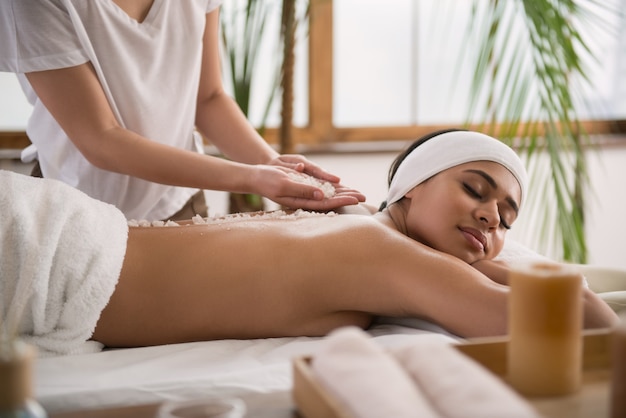 Absolutely peaceful. Peaceful young woman feeling relaxed while enjoying the massage