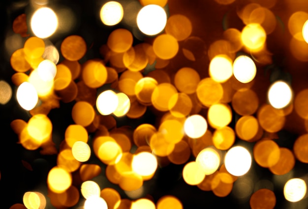 Abstract Abstract festive Christmas background with lights of blurred golden bokeh on black