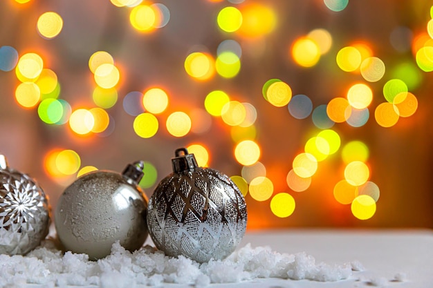 Abstract advent christmas background winter decorations ornaments balls on background with snow and defocused garland lights merry christmas time concept