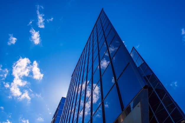 Abstract architecture background with blue sky and modern office building with reflection in the window glass