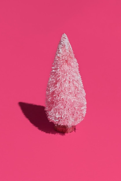 Abstract artificial pink christmas tree on a pink background cute artificial christmas tree