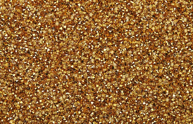 Abstract background of colorful bright golden rhinestone strass crystals, elevated top view, directly above