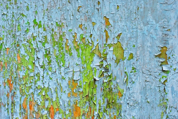 Abstract background of cracked weathered old wood with layers of paint