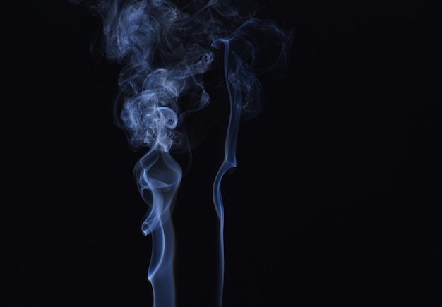 Abstract background of dynamic white smoke on black backdrop