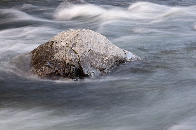 Abstract background from long exposure of water stream in a mountain river close-up