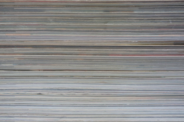 Abstract background is a stack of sheets from magazines and newspapers.