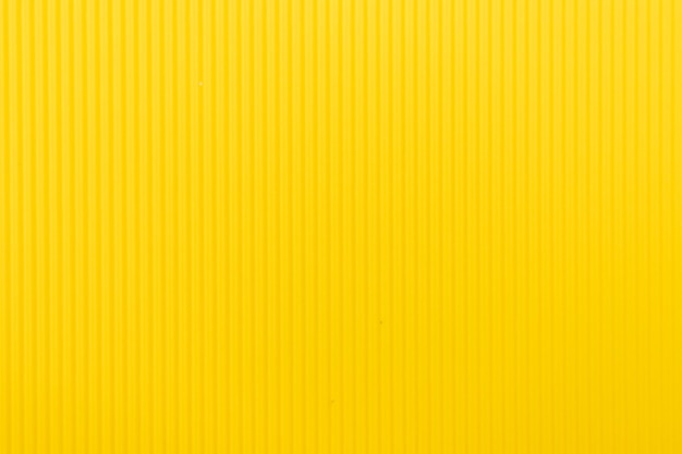 Abstract background made of corrugated paper for yellow\
application space for text texture vertical stripes