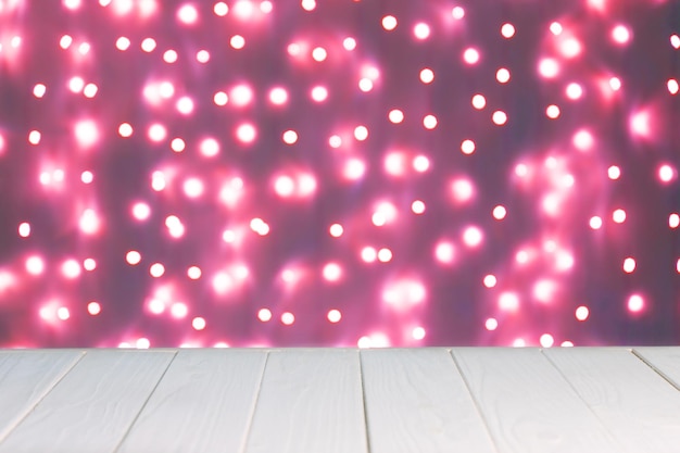 Mockup di sfondo astratto luci rosa sfocate bokeh e superficie di legno bianca