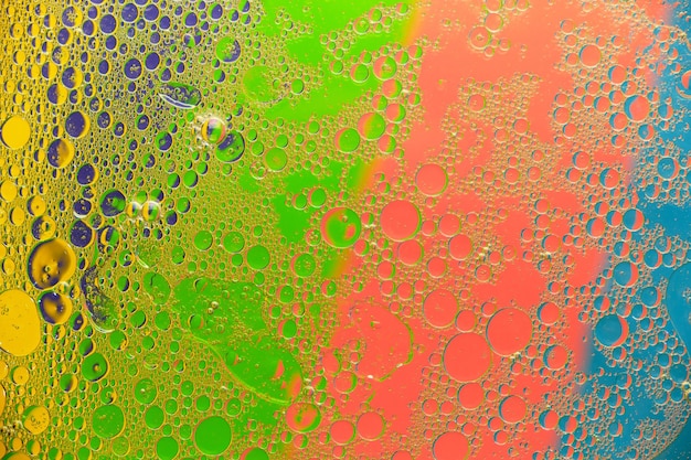 Фото Абстрактные фоновые масляные пятна и пятна на поверхности воды на ярком цветном фоне.