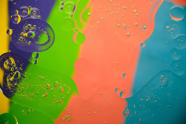 Abstract background oil stains and stains on the surface of water on a bright colored background.