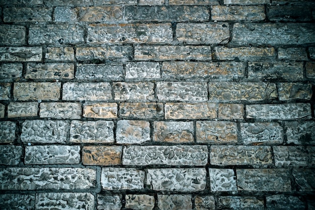 Abstract background of old cobblestone pavement. Grey stone brick paving texture. Close up of ancient road. Walking in an old city. Old bricks texture. Ancient road construction.