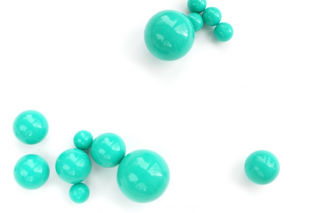Abstract background of plastic green beads of different size on a white background