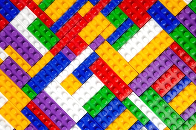 Abstract background texture of colored constructor blocks Background of colorful plastic part of constructor Pile of colored toy bricks