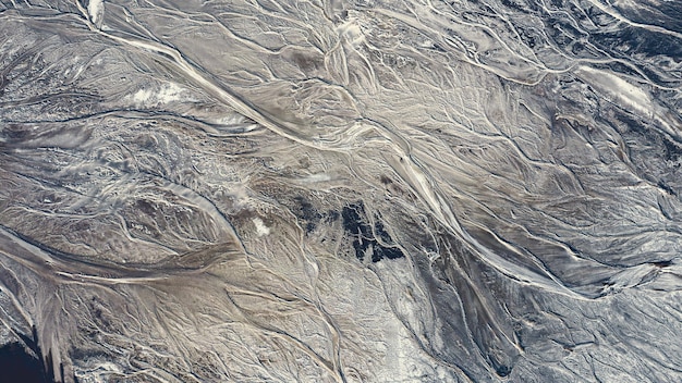 Абстрактный фон или текстура, изображающая волнистый узор земли и воды, текущей по земле красивый естественный узор с большой высоты искусственное озеро