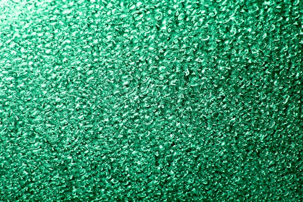 緑色のガラスまたは金属の抽象的な背景の水滴