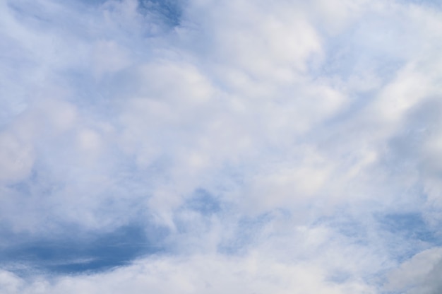 明るい青空に白いふわふわの雲の抽象的な背景。