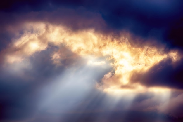Photo abstract background with amazing dramatic sky at sunset. sun rays shining through the clouds.