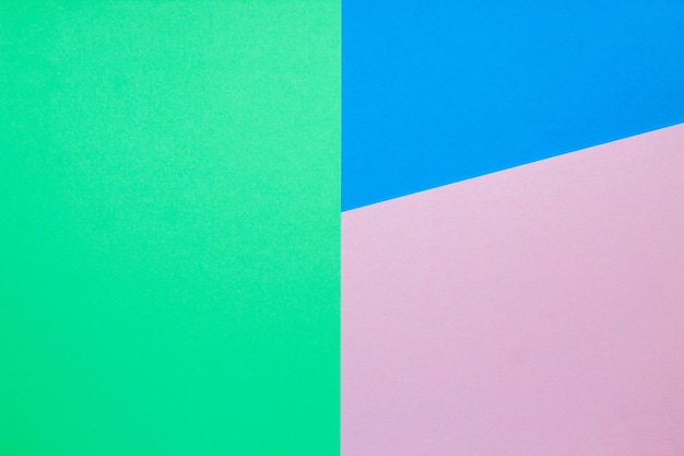 분홍색과 녹색 색상이 있는 파란색 색종이가 있는 추상 배경