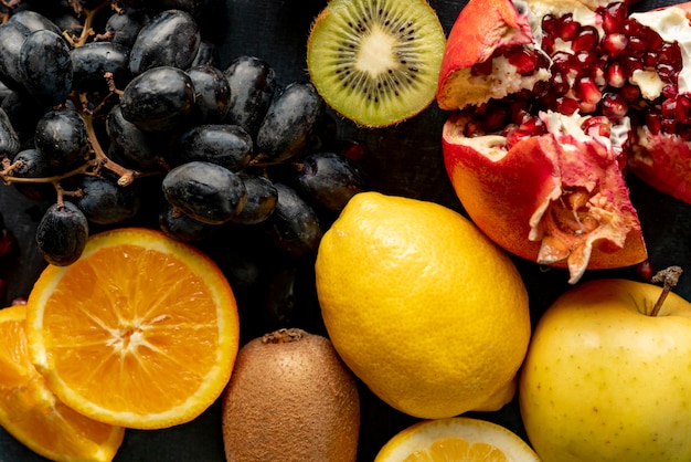 Abstract background with fresh organic fruits such as sliced orange kiwi grapes and garnets