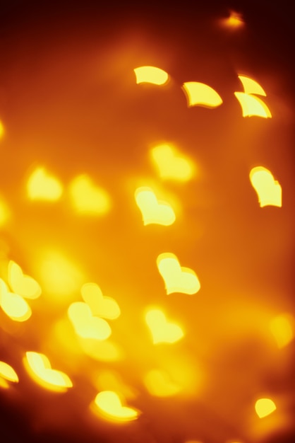 Фото Абстрактный фон с золотыми размытыми огнями в форме сердца. день святого валентина