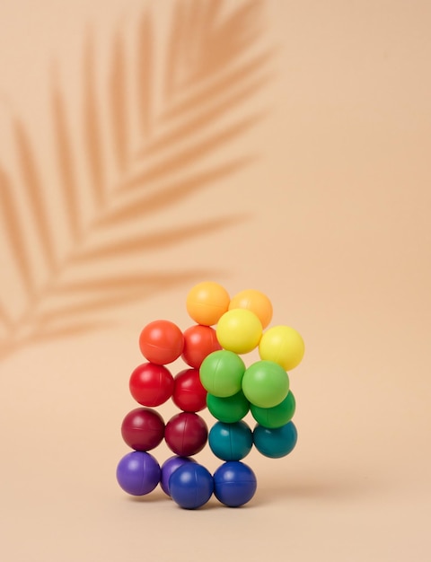 Abstract background with multicolored plastic balls on a beige background a stage for the demonstration of cosmetics and productsx9