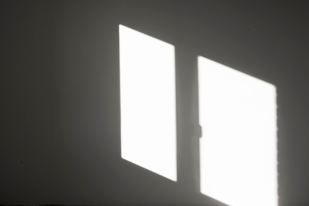 Photo abstract background with reflection of sunlight from a window in an empty room on a gray wall