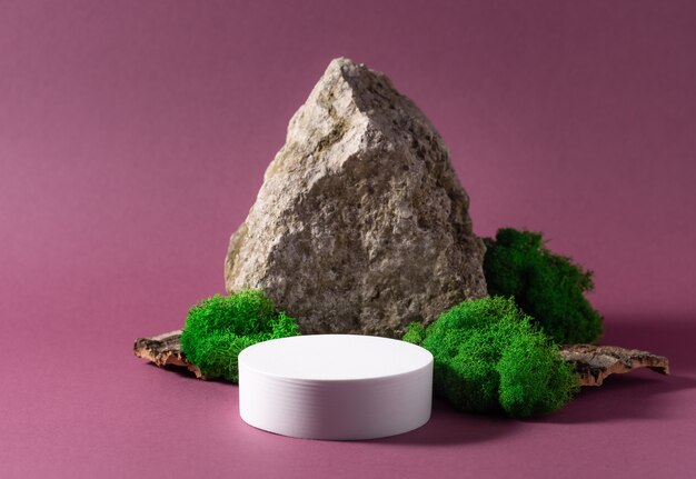 Abstract background with white podium, natural stone and moss