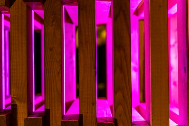 Abstract background of wooden slats illuminated with purple neon light